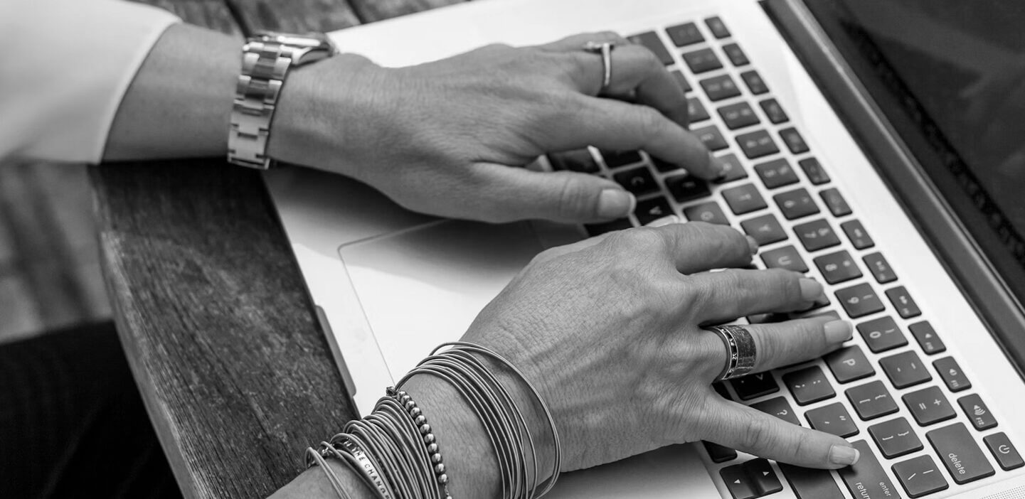 Close-up image of hands typing on a computer keyboard