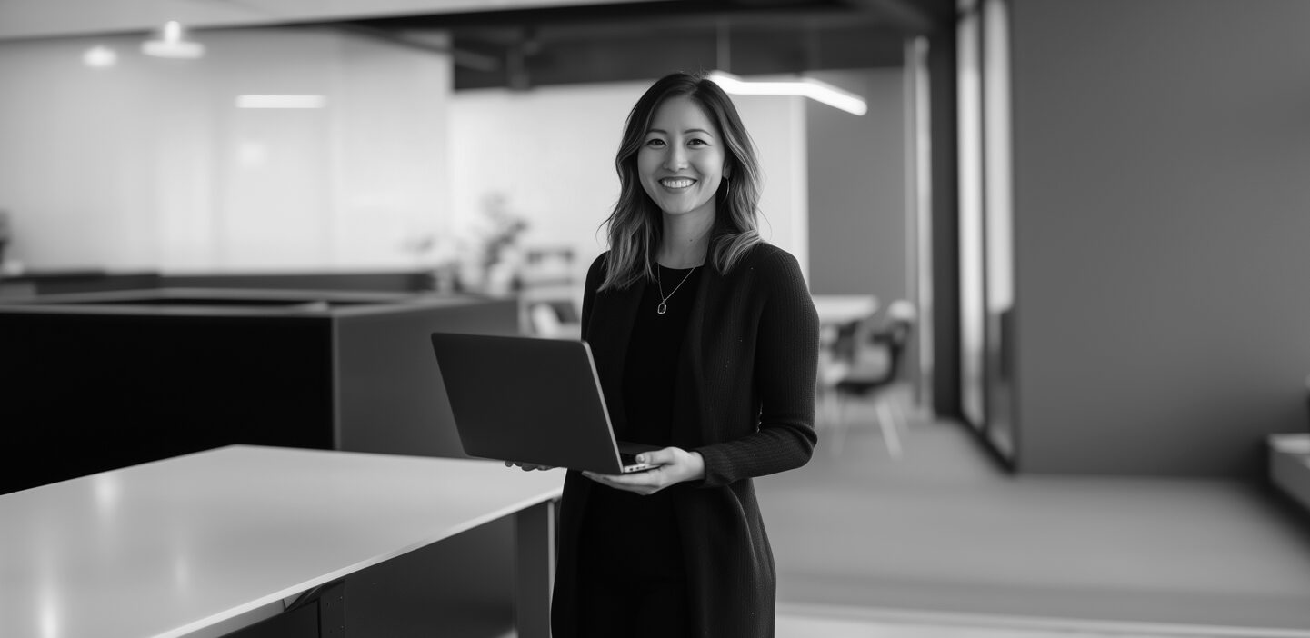 Young woman holding a laptop and smiling