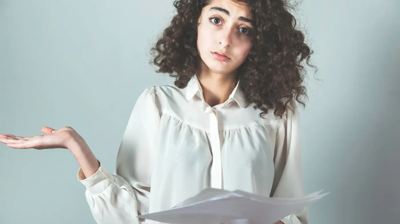confused woman holding paper