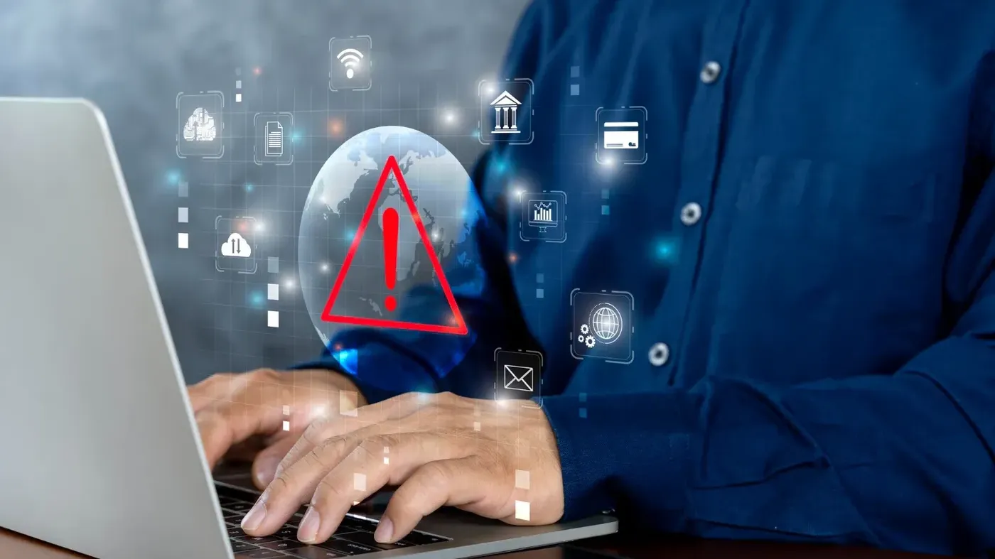 person typing on computer with warning