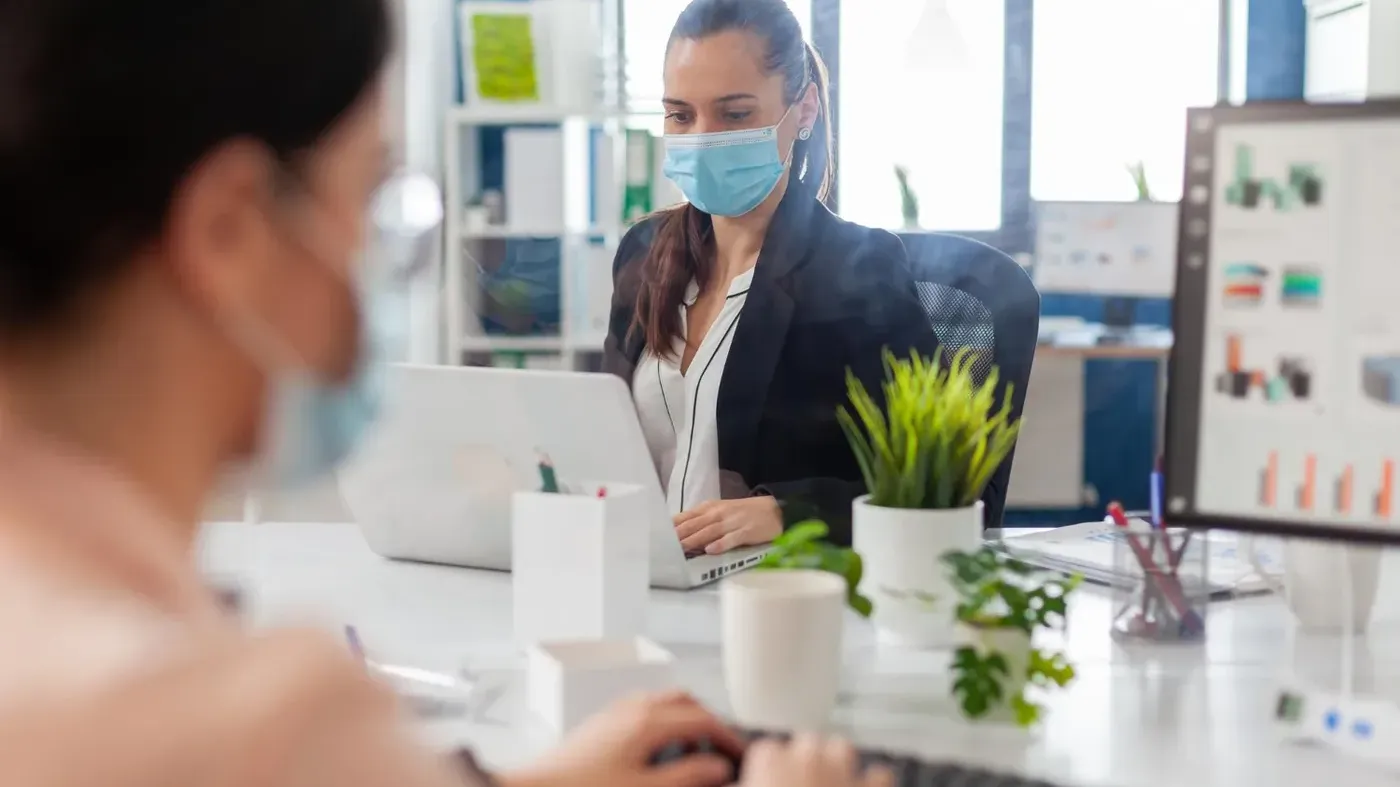 woman with mask on computer