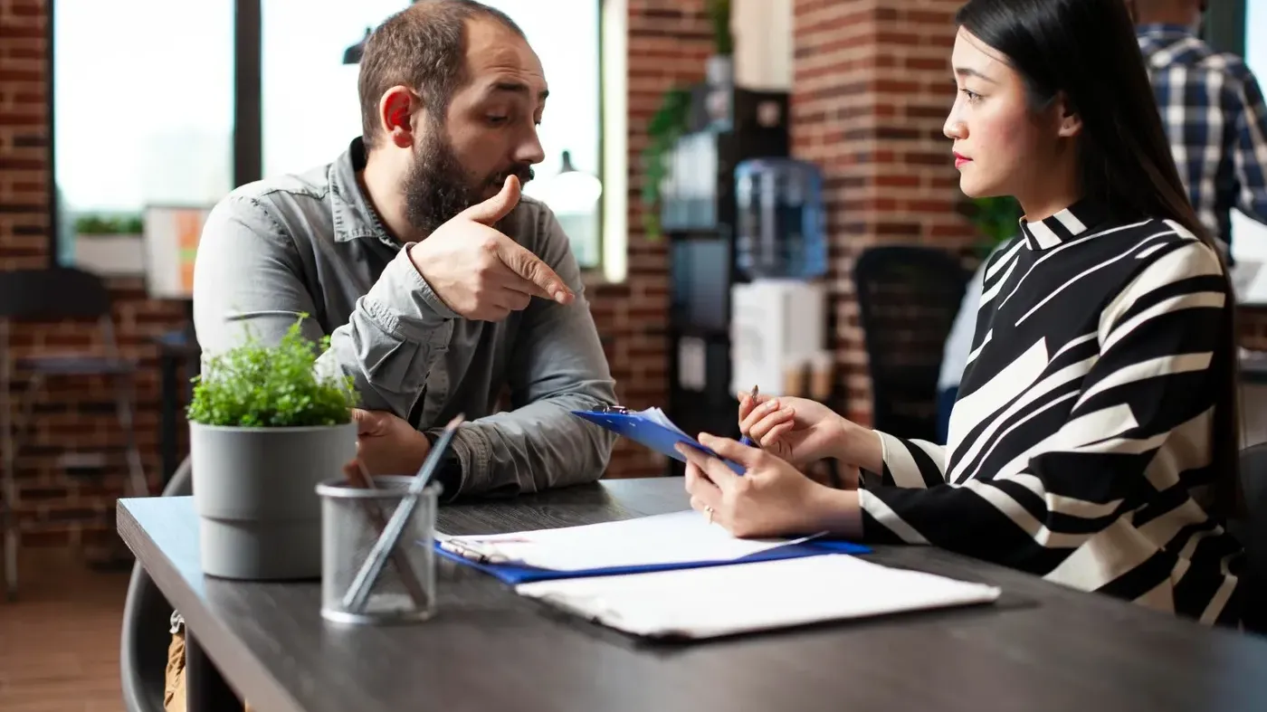 Small business owner reviews policy with insurance professional at a table